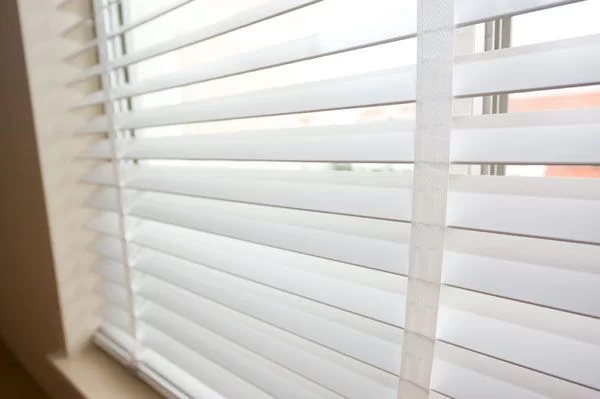 Close-up of white faux wood blinds
